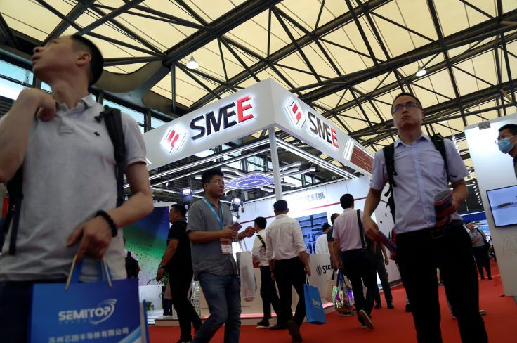 Visitantes passam pelo estande da Shanghai Micro Electronics Equipment (SMEE) durante a Semicon China em 2023. Foto: Reuters
