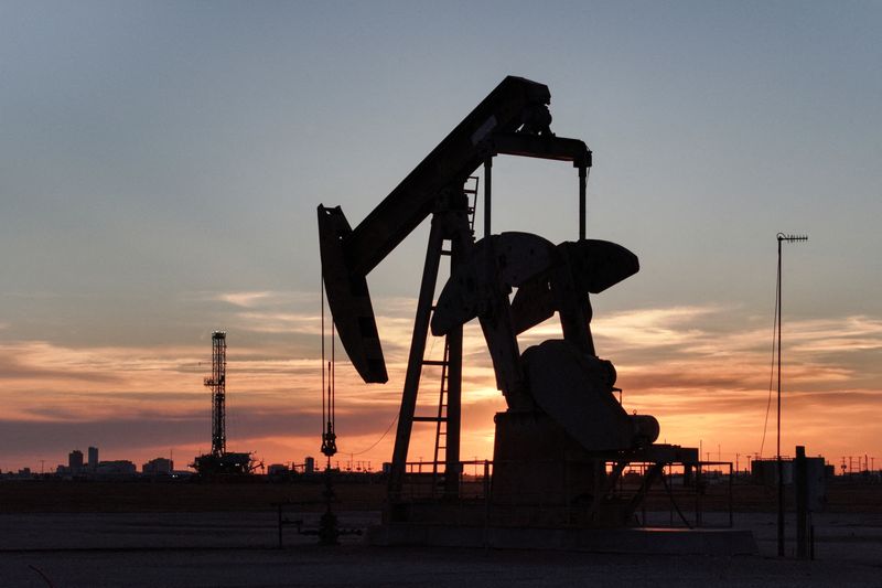 Bomba de extração de petróleo (pumpjack) ao pôr do sol no Texas