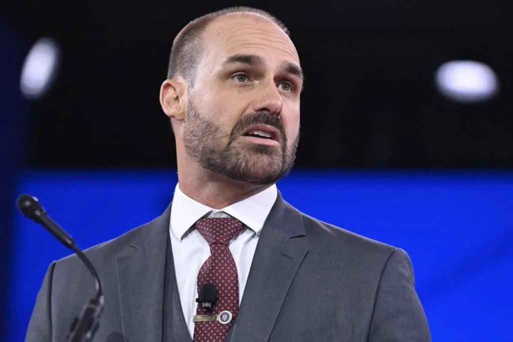 O ex-deputado Eduardo Bolsonaro discursa em evento, com microfone à frente. (Foto: cartacapital.com.br)